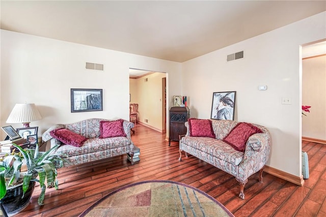 living area featuring visible vents, baseboards, and wood-type flooring