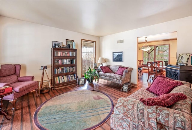 living room featuring a wealth of natural light, visible vents, and hardwood / wood-style floors