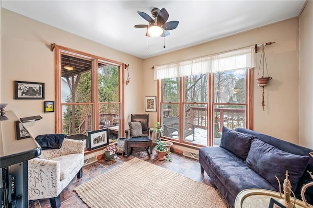 living area with a wealth of natural light and a ceiling fan