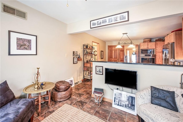 living area featuring baseboards and visible vents