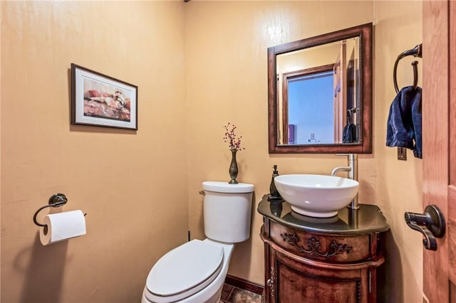 half bath with vanity, toilet, and baseboards