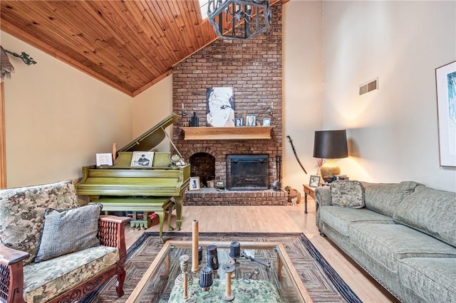 living room featuring wood finished floors, visible vents, high vaulted ceiling, a fireplace, and wood ceiling