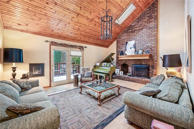 living area with high vaulted ceiling, wood finished floors, a skylight, wooden ceiling, and a brick fireplace