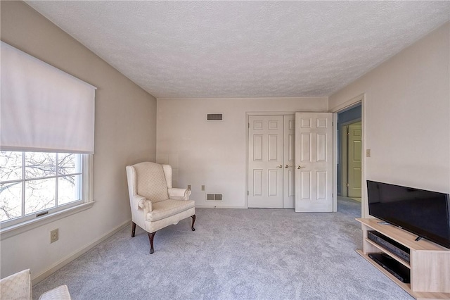 living area featuring visible vents, carpet flooring, and baseboards