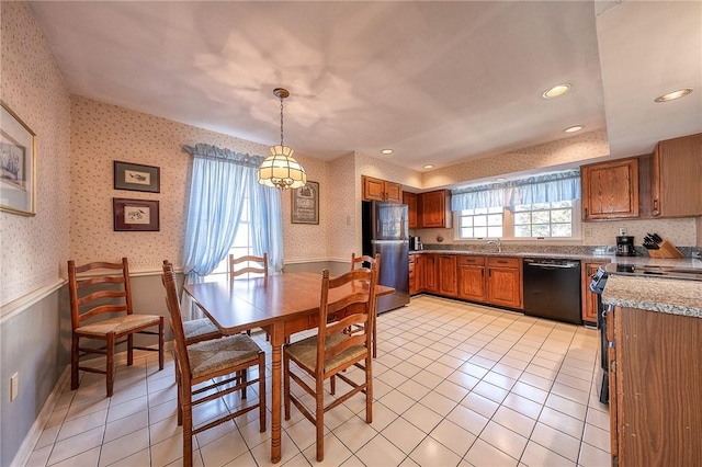 kitchen with wallpapered walls, black appliances, a wainscoted wall, and brown cabinets