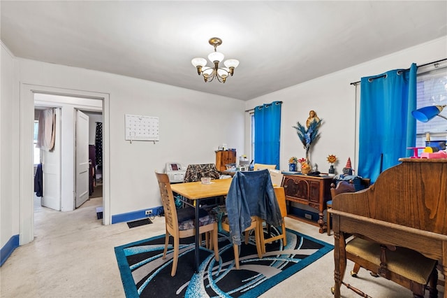 dining room featuring baseboards, light colored carpet, and a chandelier