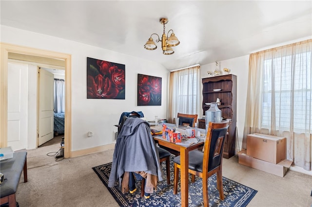 carpeted dining room with baseboards and a chandelier