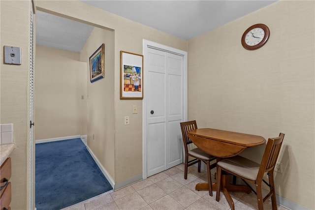 dining area with baseboards and light tile patterned flooring