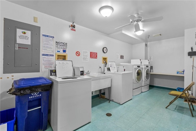 community laundry room featuring washer and dryer, electric panel, light floors, and ceiling fan