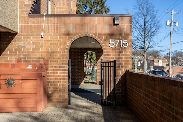 entrance to property with a gate and brick siding