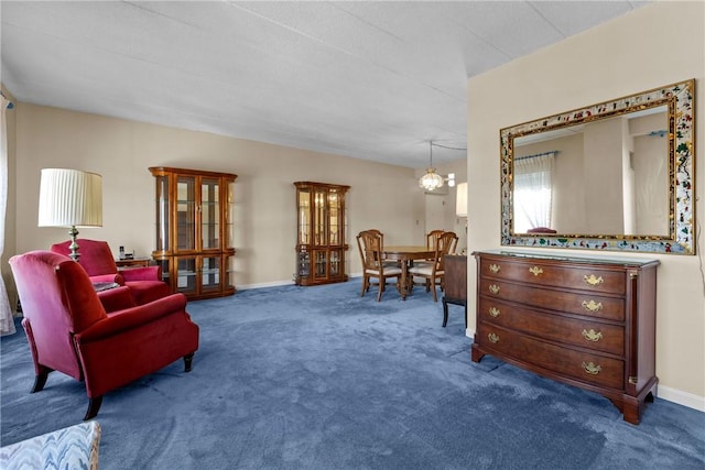 sitting room featuring baseboards, carpet, and an inviting chandelier