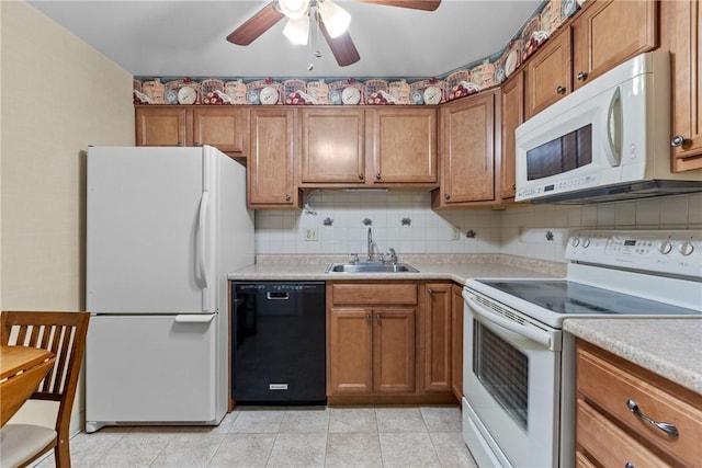 kitchen featuring brown cabinets, a sink, tasteful backsplash, white appliances, and light countertops