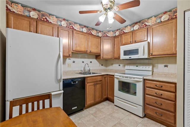 kitchen with brown cabinets, white appliances, light countertops, and a sink