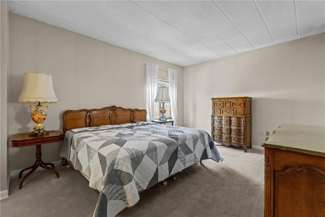 bedroom with light colored carpet and baseboards