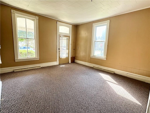 empty room with a wealth of natural light, visible vents, baseboards, and carpet