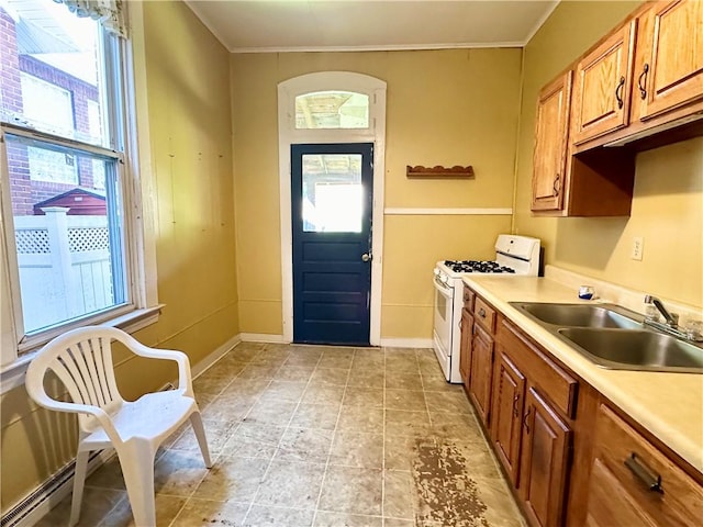 kitchen with a sink, plenty of natural light, white gas range, and light countertops