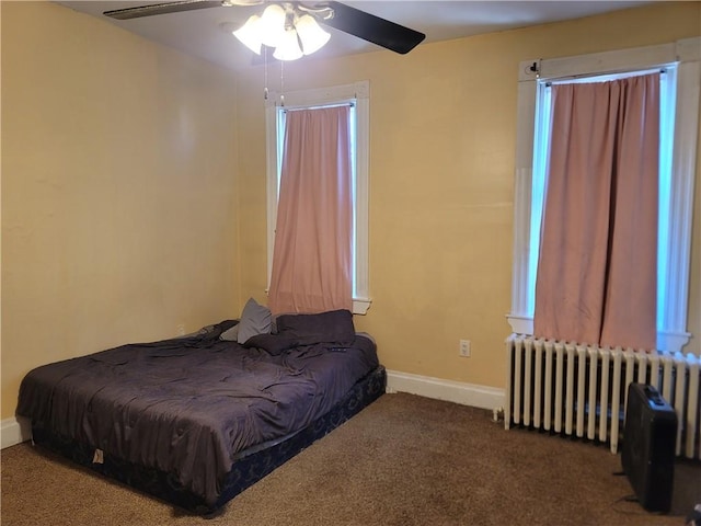 bedroom featuring baseboards, radiator heating unit, carpet, and a ceiling fan