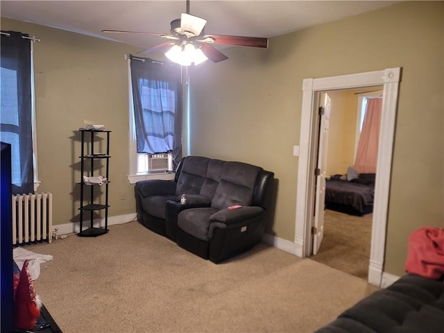 carpeted living area featuring cooling unit, radiator, baseboards, and a ceiling fan