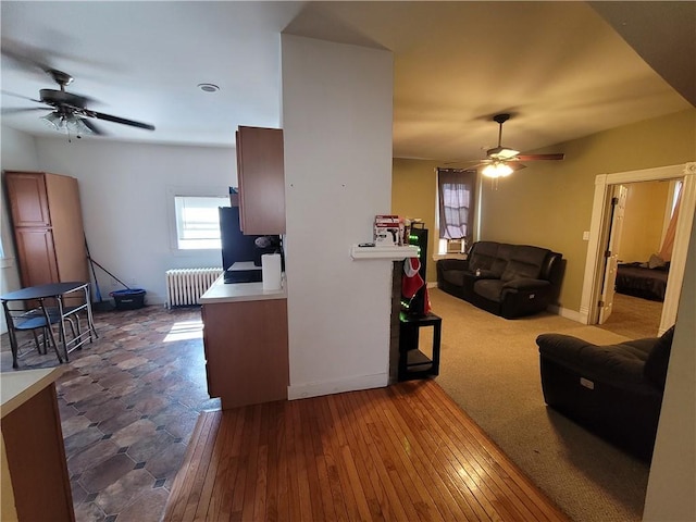 interior space with baseboards, a ceiling fan, dark wood finished floors, and radiator heating unit