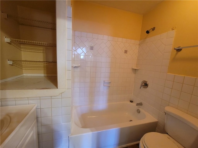 full bathroom featuring toilet, tub / shower combination, tile walls, and vanity