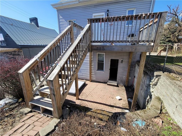 rear view of property featuring stairway, a patio, and a deck