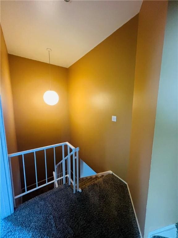 staircase with baseboards and carpet floors