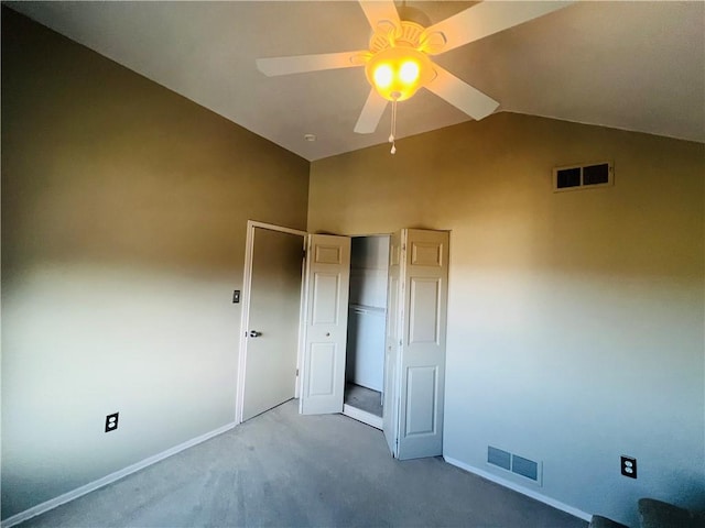 unfurnished bedroom featuring visible vents, lofted ceiling, carpet floors, and a closet