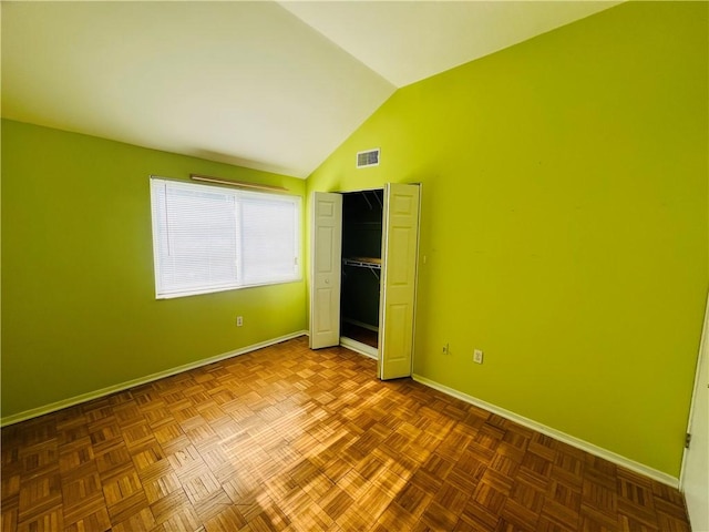 unfurnished bedroom with lofted ceiling, baseboards, visible vents, and a closet