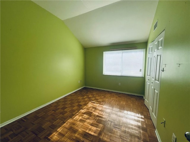 unfurnished bedroom with visible vents, baseboards, a closet, and vaulted ceiling