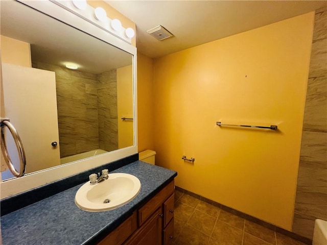 full bathroom with tile patterned flooring, visible vents, walk in shower, baseboards, and vanity