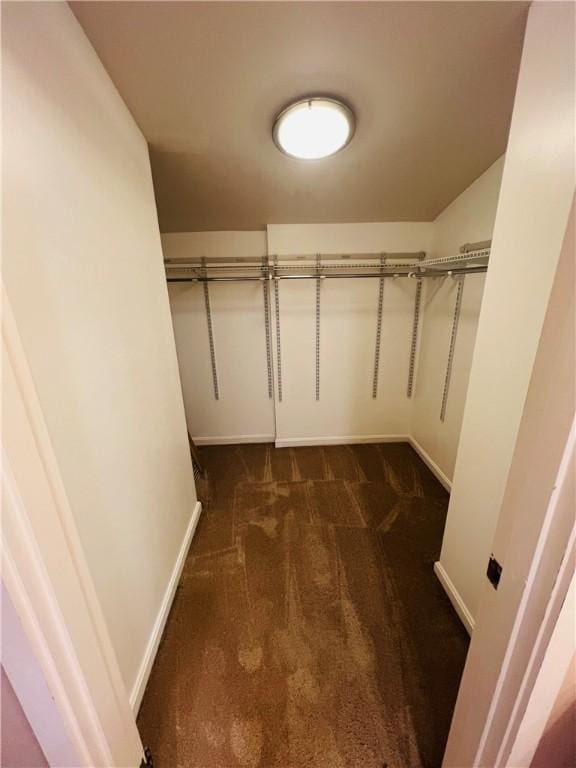 spacious closet featuring dark carpet