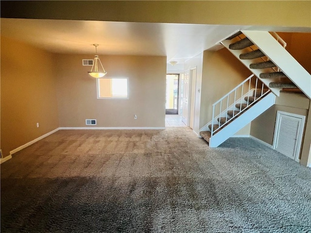 unfurnished living room with visible vents, carpet flooring, stairs, and baseboards