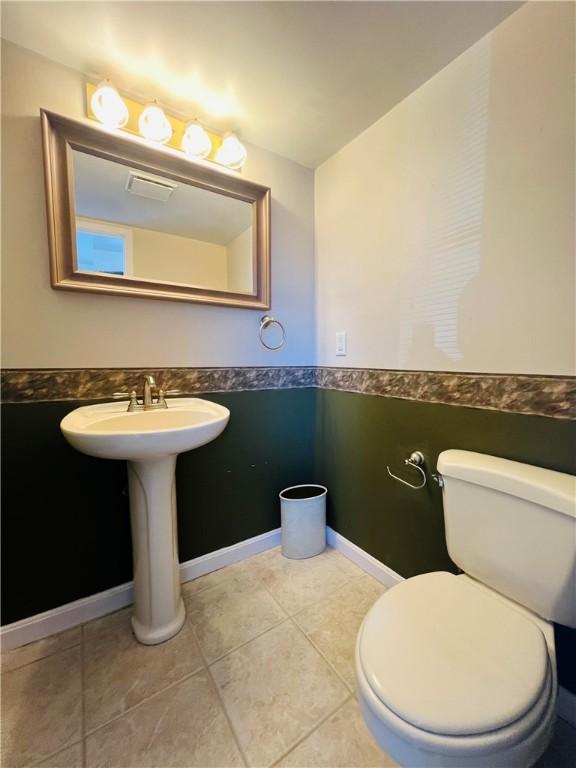 bathroom featuring tile patterned floors, toilet, visible vents, and baseboards