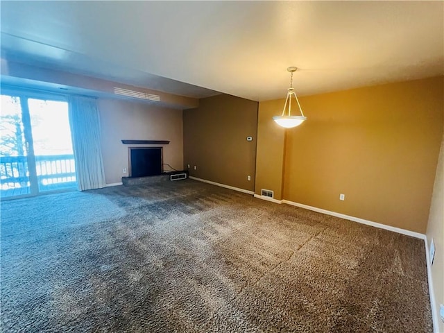 unfurnished living room with visible vents, a fireplace with raised hearth, baseboards, and carpet