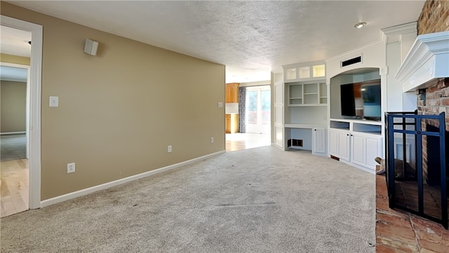 unfurnished living room featuring light colored carpet, a textured ceiling, and baseboards