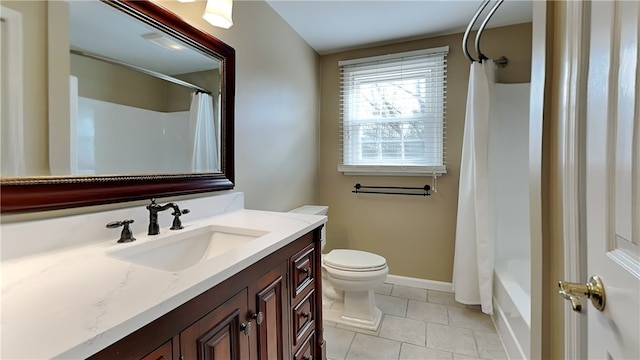 bathroom featuring baseboards, toilet, vanity, and tile patterned flooring