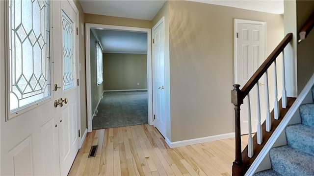 interior space featuring stairs, baseboards, visible vents, and light wood finished floors