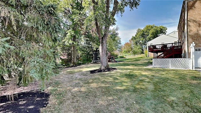 view of yard featuring a deck, stairs, and a garage