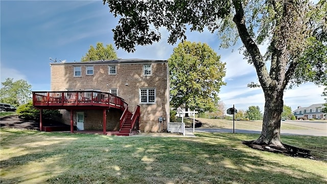 back of property with brick siding, a yard, a deck, and stairway