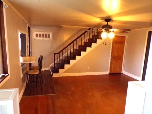 interior space with visible vents, baseboards, wood finished floors, and a ceiling fan