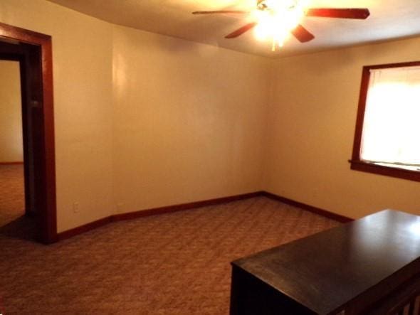 interior space featuring baseboards and a ceiling fan