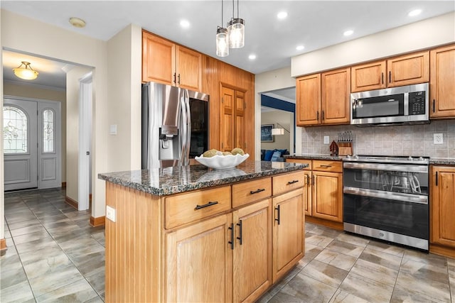 kitchen featuring pendant lighting, a center island, stainless steel appliances, dark stone counters, and decorative backsplash