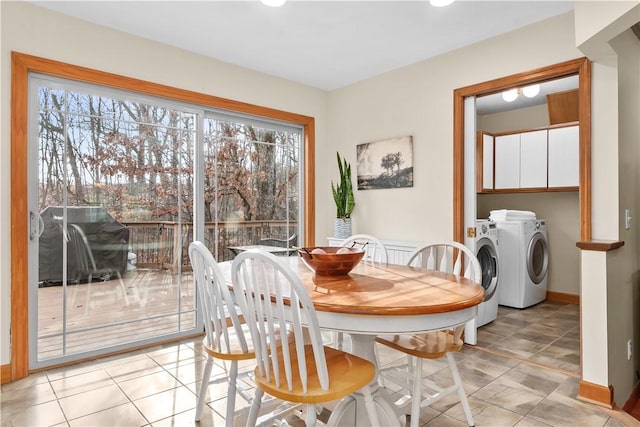 dining area featuring light tile patterned floors, baseboards, and independent washer and dryer