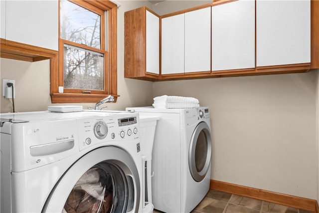 laundry area featuring baseboards, cabinet space, and separate washer and dryer