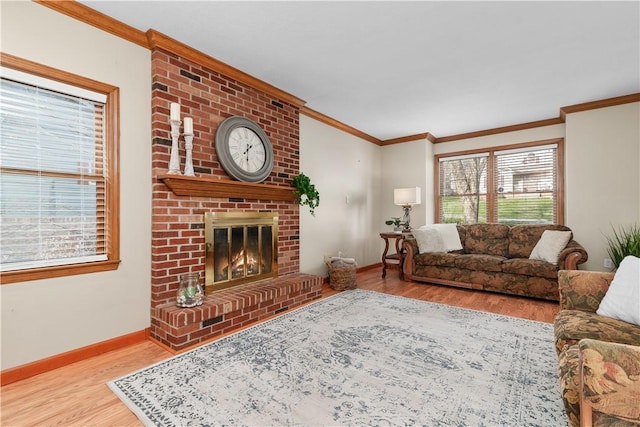 living room featuring baseboards, a brick fireplace, wood finished floors, and crown molding