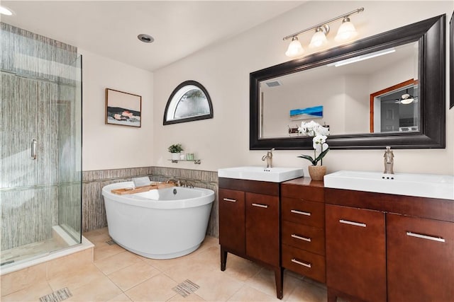 full bathroom featuring a sink, double vanity, a shower stall, and tile patterned floors