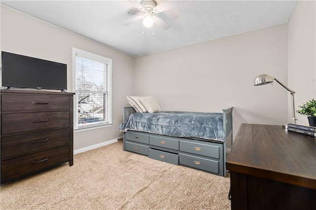 bedroom featuring light colored carpet, baseboards, and ceiling fan