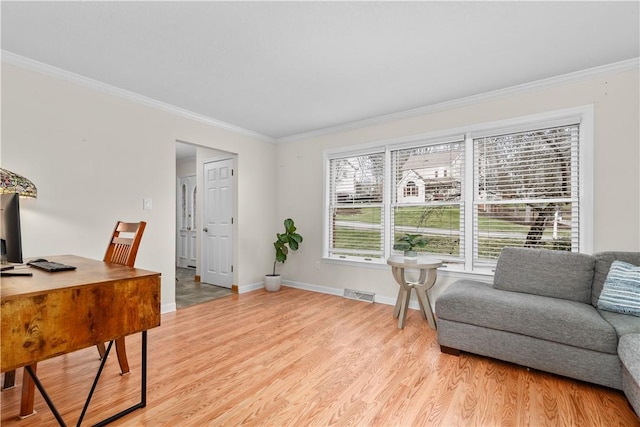 office area featuring crown molding, light wood-style floors, visible vents, and baseboards