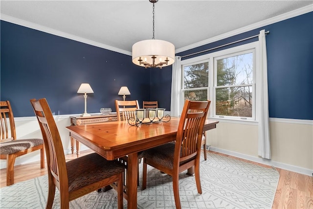 dining area with crown molding, light wood-type flooring, and baseboards