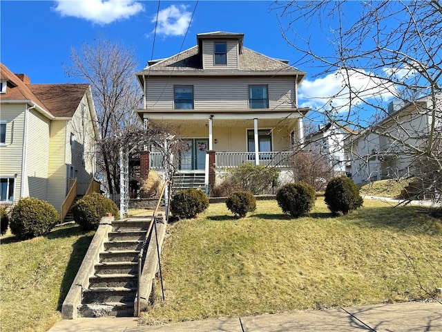 traditional style home featuring stairs, a front lawn, covered porch, and a shingled roof